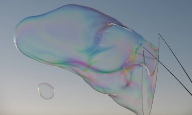 Büyük sabun köpüğü. Mavi gökyüzünde renkli sabun köpüğü