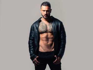 Acımasız bir adam, yakışıklı, ciddi bir erkek model. Güçlü kaslı erkek vücudu, kaslı adam. Üstsüz maço adam. Vahşi adamın moda portresi.