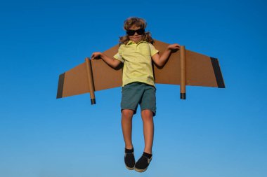 Çocukluk hayalleri, çocukluk hayalleri, macera yolculukları. Çocuklarla seyahat ve tatil. Çocukların özgürlüğü ve tasasız konsepti. Mavi gökyüzüne karşı çocuk pilot