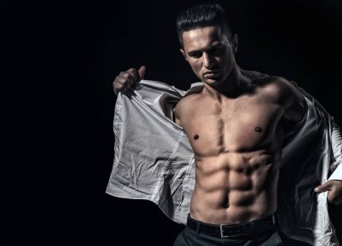 Kaslı vücudu ve çıplak gövdesi olan seksi bir adam. Kaslı, üstsüz, çekici bir adam. Atletik adam, fitness modeli. Seksi gövde. Erkek kaslarını esnetiyor. Spor vücut geliştirme.