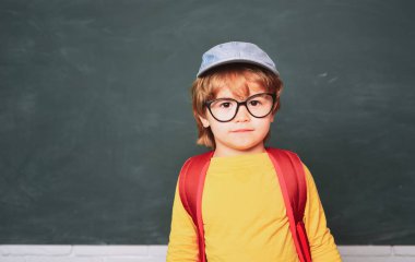 Okul malzemeleri ile masa nın yanında mutlu yüz ifadesi ile sevimli çocuk. Evde eğitim. Okul çocukları. Öğrenme kavramı.