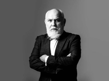 Kolları bağlı, Takım Elbiseli Adam. Sakallı, orta yaşlı, ciddi bir yüz ifadesi olan, yakın plan bir kafa ve omuz portresi olan adam.