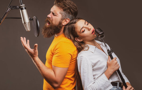Couple duet with microphone singing song. Musician in music hall