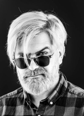 Gri arka planda poz veren yakışıklı sakallı adam. Stüdyoda karanlık arka planda yakışıklı bir adamın portresi.