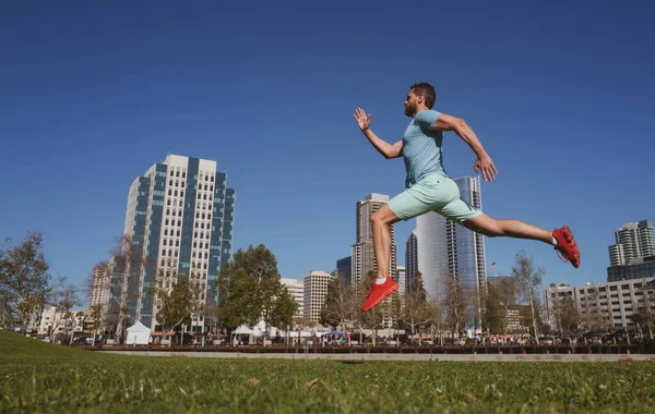 Athletic young man running in city San Diego. Urban sport concept