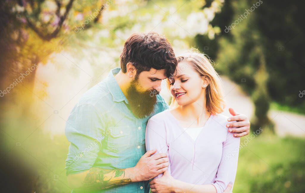 Passion and sensual touch. Couple in live walking in the spring Park and enjoying the beautiful spring blossom nature.