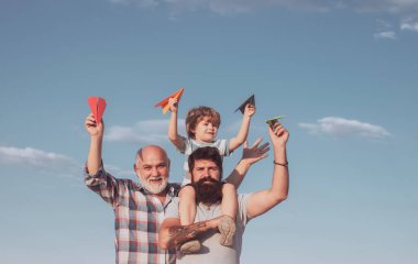 Baba ve oğul. Baba ve oğul mavi yaz gökyüzünde oynuyorlar. Babalar günü konsepti. Çok nesil