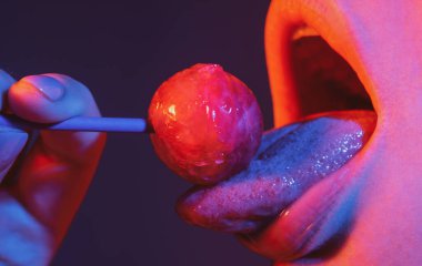 Dilini yalıyor. Seksi ağzı olan, chupa yiyen bir kız. Kadın dudakları lolipop emiyor. Ağzında lolipop tutan kadın, kapat. Kırmızı dudaklar, şehvetli ve seksi konsept.
