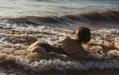Back view sexy young woman posing on the beach. Beautiful woman relaxing at the ocean. Sexy curves girl butt