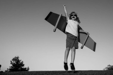 Çocukların lideri ve kazananı, başarı başlar. Heyecanlı çocuk, parkta oyuncak jetpack kanatlarıyla oynuyor.