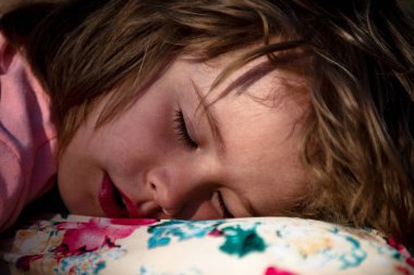 Yatakta yatan ve uyuyan bebeğin yüzünü kapat. Çocuk evde yatakta sakince uyur. Bebek battaniyenin altında sırtüstü yatar, sağlıklı uyur.