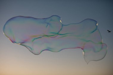 Büyük sabun köpüğü. Mavi gökyüzünde renkli sabun köpüğü