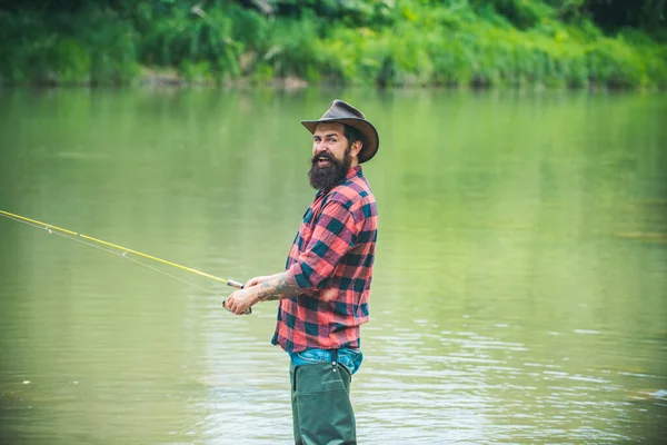 Fishing hobby and spring weekend. Bearded men fisher with fishing rod and net