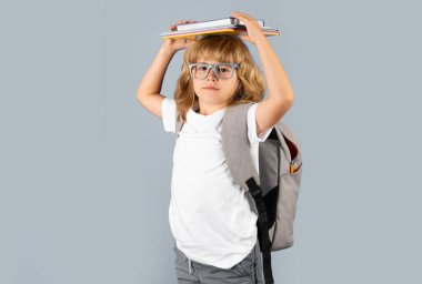 Öğrenci portresi, gri izole stüdyo geçmişi üzerine kitap tutuyor. Okul ve eğitim kavramı. Okula geri dön.