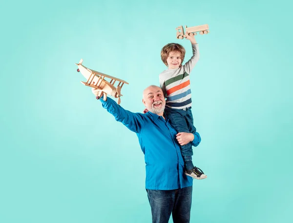 Child boy and grandfather piggyback with toy plane and wooden truck. Men generation granddad and grandchild