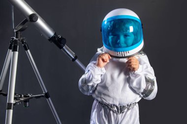 Uzay çocukları kozmonot konsepti. Teleskoplu, kasklı, neşeli bir çocuğun portresi. Kopya alanı ile izole edilmiş arkaplan. Astronomi ve astroloji kavramı