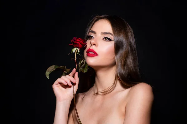 赤いバラの花を持つ美しい女性 赤い唇とバラ 黒を背景にした美人 官能的なセクシー口 — ストック写真