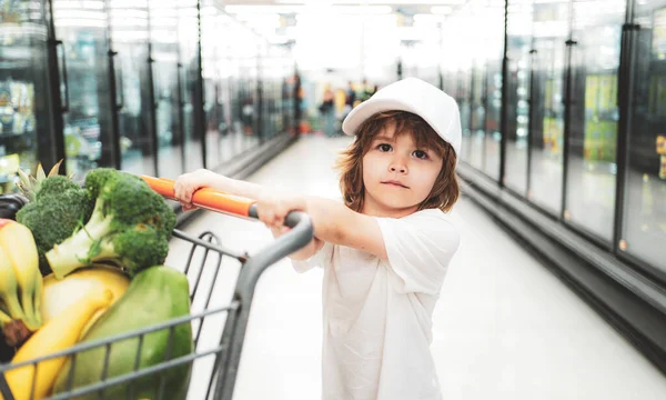 食品店や新鮮な有機ニンジンを選択するスーパーマーケットでかわいい幼児の男の子 子供を持つ若い家族のための健康的なライフスタイル — ストック写真