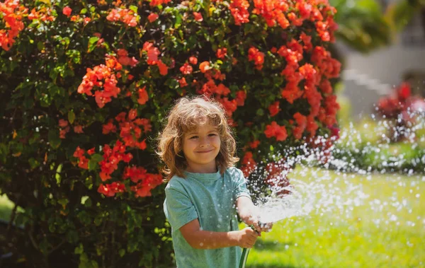 소년은 호스에서 붓습니다 정원에서 꽃에게 주는아이 의정원가꾸기 — 스톡 사진