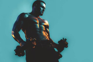 Seksi, kaslı vücut. Güçlü Formlu Adam Dambıllarla egzersiz yapıyor. Ağırlık kaldıran adam. Çıplak, Çıplak Gövde