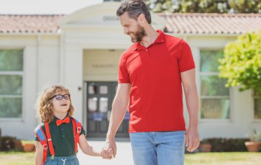 Baba oğlunu destekliyor ve motive ediyor. Çocuk ilkokula gidiyor. Okula dön ve mutlu ol.