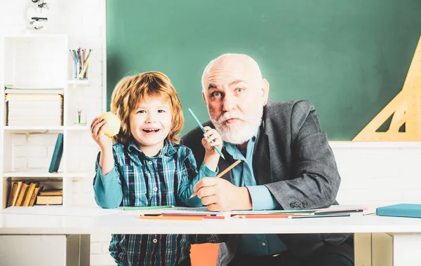 Portrait of happy grandfather and Son in classroom. Grandfather and grandchild - generation people concept. A grandfather and a son are learning in class. Back to school