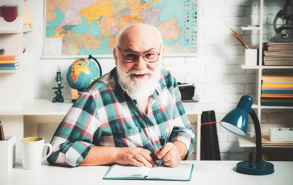 Sınıfta kıdemli öğretmen. Öğrenme ve eğitim konsepti, tahtada öğretmenlik. Öğretmen tahtaya yakın. Üniversite eğitimi