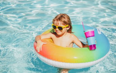 Komik çocuk bilardoda kokteyl içer. Aquapark 'taki çocuk, yaz tatili.