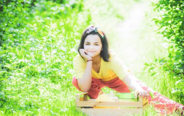 Portrait of kid gardener carrying harvested in farm. Child spend time in the orchard. Child farmer in the farm with countryside background