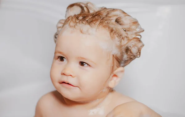 孩子在洗澡给宝宝洗澡快乐的孩子头上戴着肥皂泡沫洗澡间里有蓬松肥皂泡的小孩 — 图库照片