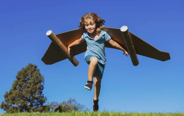 青い空に向かってジャンプする紙の翼で走る幸せな子供 おもちゃのジェットパックで遊んで男の子の肖像画 自由屈託のない 成功者 革新と想像力の概念 — ストック写真