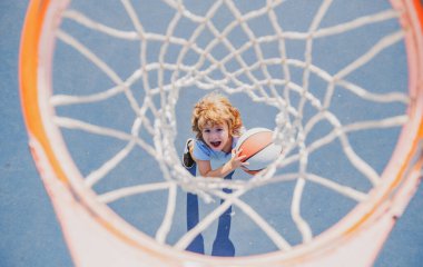 Gülen yüzüyle basketbol oynayan harika bir çocuk.