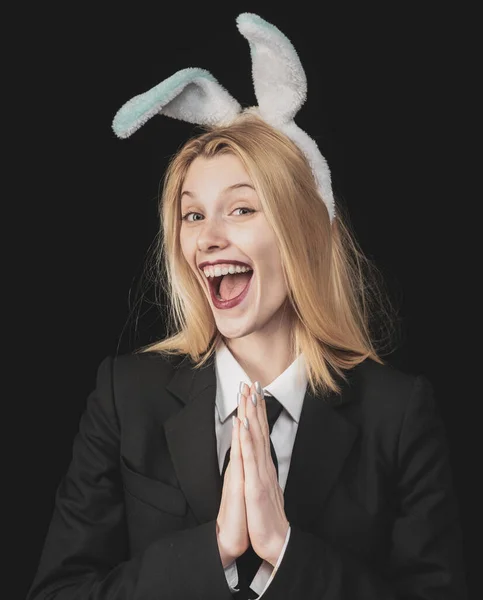 Sexy model dressed in costume Easter bunny. Egg hunt. Sexy woman with mask Easter bunny on a black background and looks very sensually. Easter dinner menu. Blonde woman in rabbit bunny ears