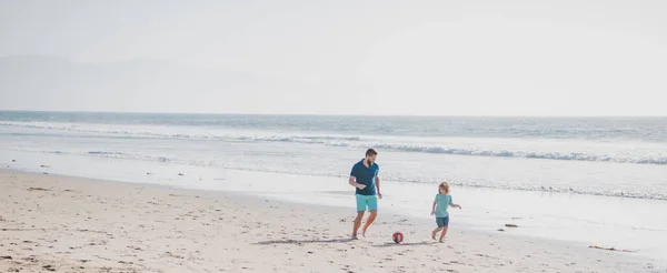 パパと子供が屋外で遊んでる 幸せなスポーティな家族の概念 父と息子はビーチでサッカーやサッカーをする — ストック写真