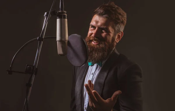 Classical music. Singing man in a recording studio. Expressive bearded man with microphone. Karaoke signer, musical vocalist