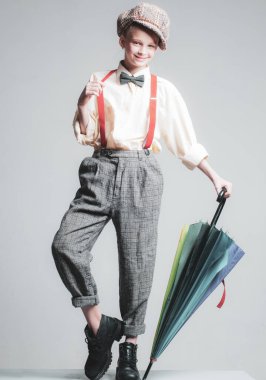Sonbahar. vintage İngilizce tarzı. şemsiye ile retro takım elbiseli genç kız. askı ve papyon. damalı bere eski moda çocuk. caz adım moda. retro model. vintage charleston parti.