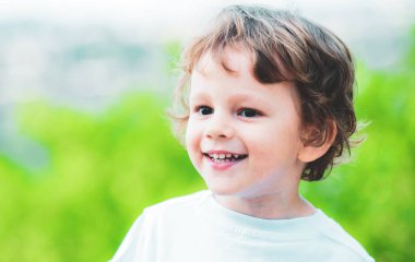 Doğadaki küçük şirin çocuk için güzel eğlenceli bir gün. Pozitif çocuk. Duygusal bir çocuk. Doğa arka planında gülümseyen çocuk portresi. Küçük çocuk hayatın ve doğanın tadını çıkarıyor. Küçük çocuk iyi yürüyüşler.