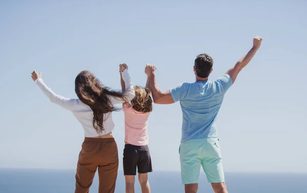 ビーチで家族のバックビュー 夏休みを楽しんでいる人たち 親は青い海に手をつないでいる 休暇旅行のコンセプト — ストック写真