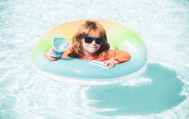 Yüzme havuzundaki çocuk şişme halkada. Küçük çocuk yüzmeyi yüzerek öğreniyor. Bebek için su oyuncağı. Çocuklar için sağlıklı bir açık hava aktivitesi. Çocuklar plaj eğlencesi