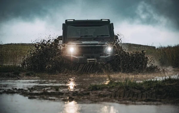 Offroad car on bad road. Off road jeep expedition to the villages on mountain road. Mud and water splash in off-road racing. Offroad car