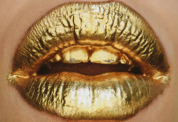 Sexy girl golden lips, gold mouth. Glowing gold skin make-up. Glitter metallic shine golden lipgloss makeup. Golden lip texture
