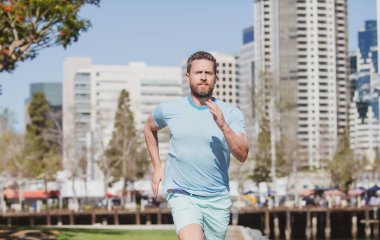 Şehir parkında koşan sağlıklı bir koşucu. Spor ve sağlıklı yaşam tarzı