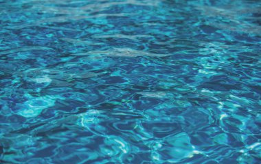 Soyut dalgalanma dalgası ve yüzme havuzunda berrak turkuaz su yüzeyi, arka plan ve soyut tasarım için mavi su dalgası
