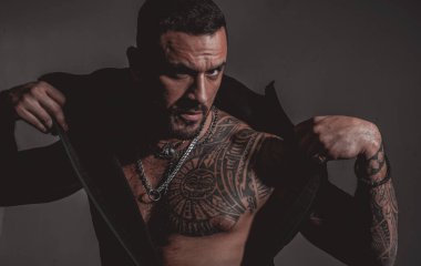 Metroseksüel adam. Çekici, modaya uygun maço. Kendine güvenen erkeksi bir bakış. Moda endüstrisi. Dövmeli kaslı, seksi bir erkek. Kendine güvenen ve yakışıklı vahşi bir adam. Erkek modası.