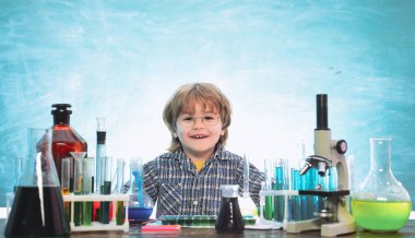 Kimya üzerine yeni bir deney yaptılar. Bilim ve eğitim konsepti. - Bilim. Küçük mutlu bilim adamı deney tüpüyle deney yapıyor. Bilgi günü.