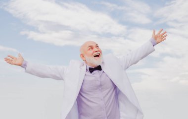 İşçilik başarısı. Yaşlı olgun adam. Beyaz takım elbiseli başarılı erkek işadamı eğleniyor.