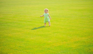 Dışarıda yeşil çimlerde sürünen sevimli bebek.