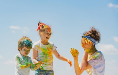 Holi festivalinin renklerine boyanmış şirin bir çocuğun portresi.