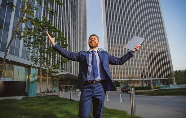 Welcome business. Happy leader standing in front of company building make winner gesture