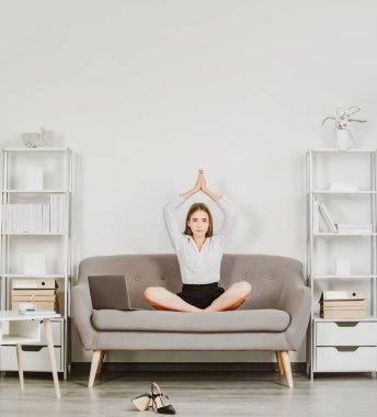Genç iş kadını serbest çalışan ya da CEO 'su iş yerinde yoga egzersizi yapan mutlu kadın sekreter ofis masasında meditasyon yapan. Çalışanlar denge uyumu rahatlığını hisseder. İş yerinde meditasyon
